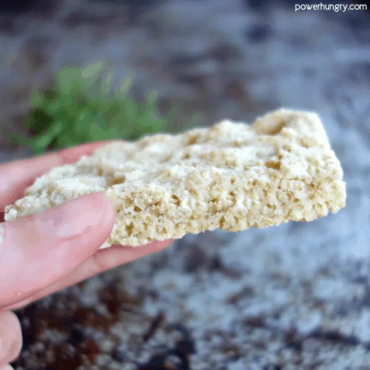 Hand holding a slice of almond flour oat foccacia