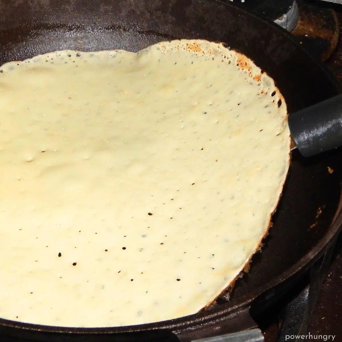 amaranth tortilla getting flipped in a nonstick skillet