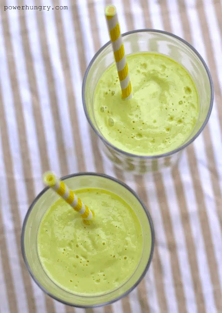 overhead shot of two glasses full of avocado banana and per smoothies