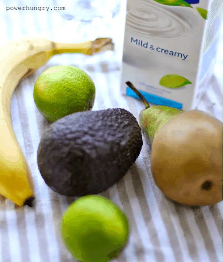 ingredients for avocado banana and per smoothies on a striped napkin