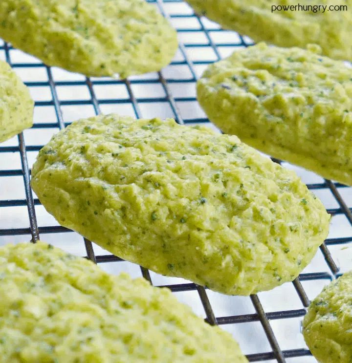 close up of baked chickpea flour broccoli tots on a black wire cooling rack