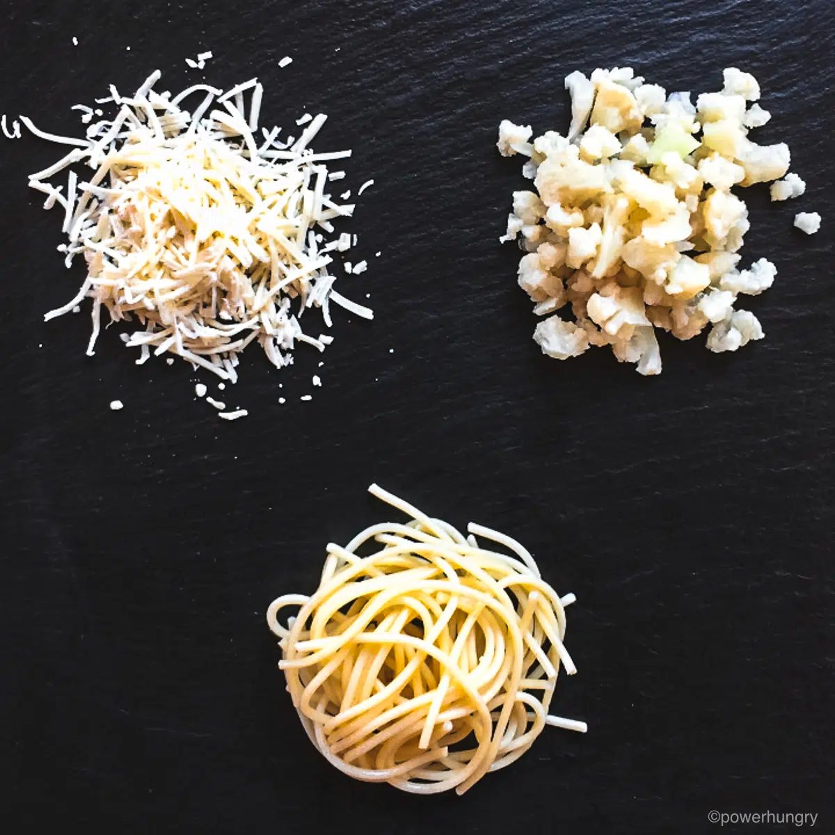 vegan cheese, cauliflower and chickpea flour spaghetti on apiece of slate