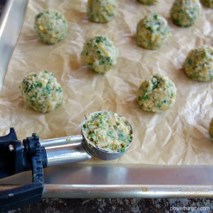 vegan pea meatballs, scooped out and rolled, ready to be baked