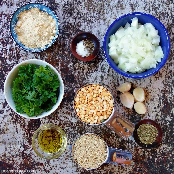 ingredients for baked split pea meatballs laid out, in small bowls, on a baking sheet