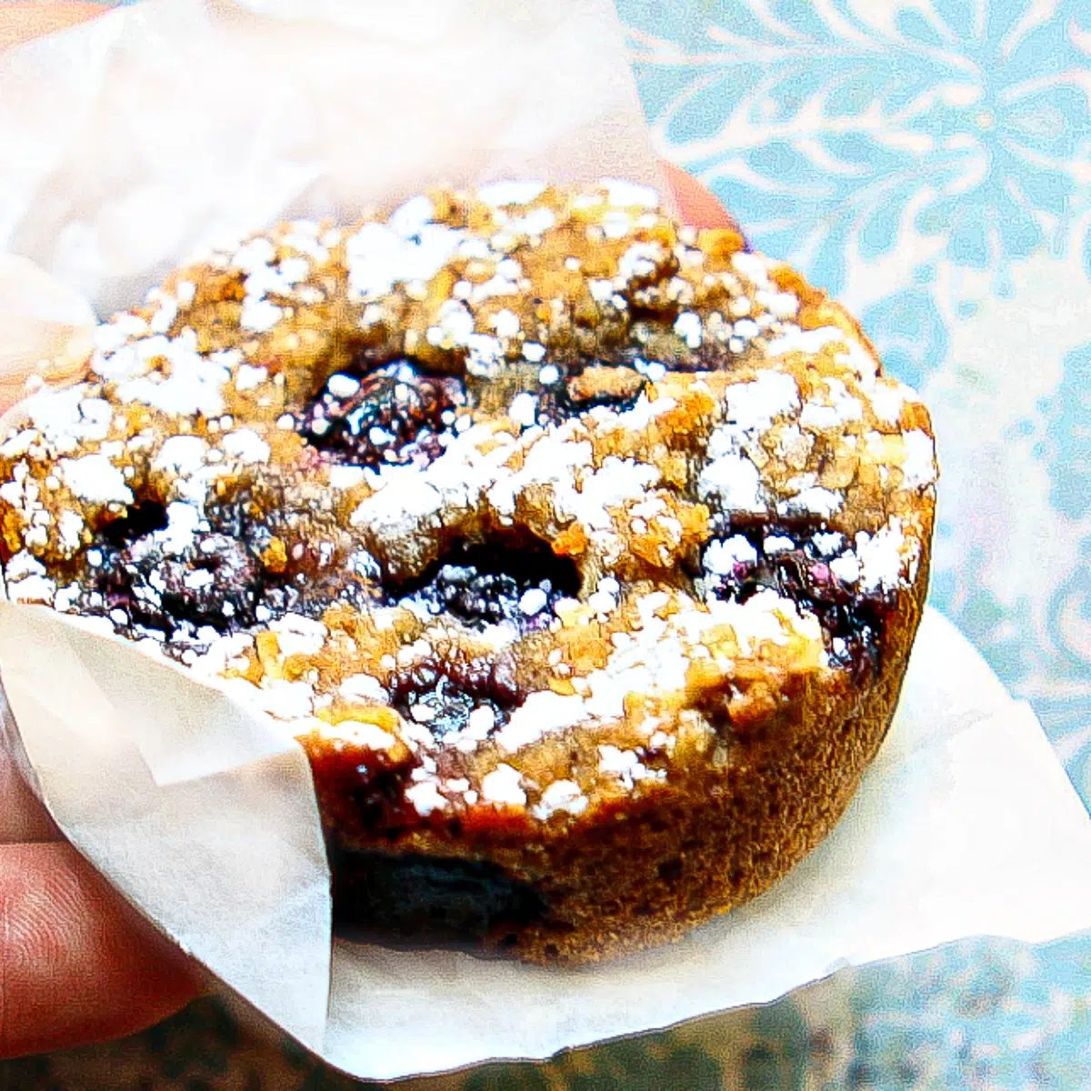 a blueberry banana breakfast cookie being held in a piece of parchment paper