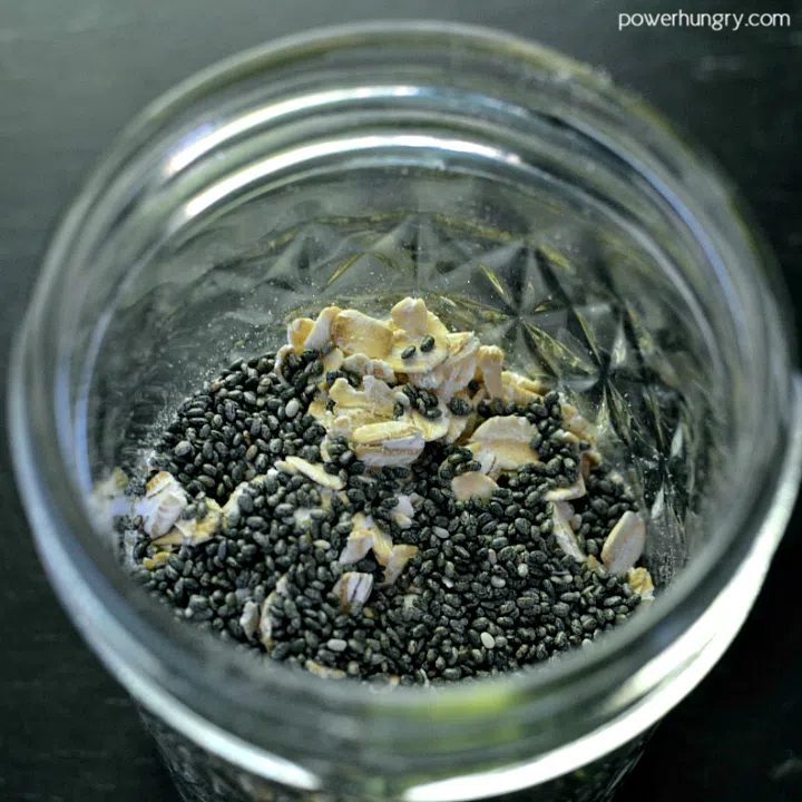 rolled oats and chia seeds in a glass jar, on top of a piece of slate
