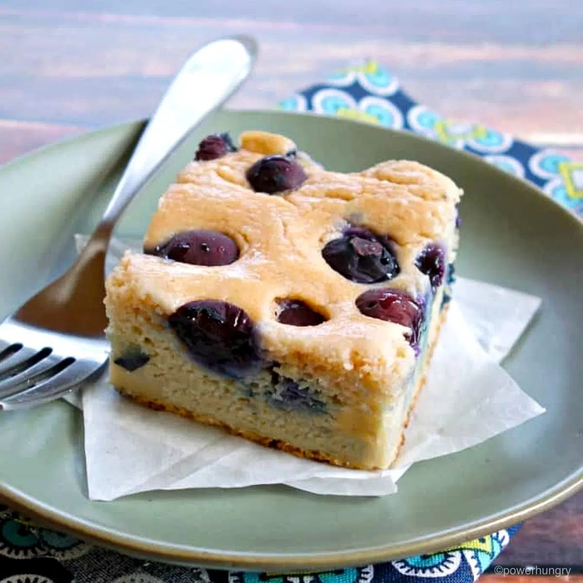 a piece of blueberry lentil bread on a n olive green plate