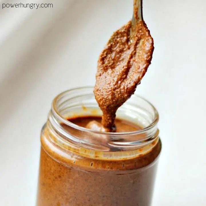 jar of all natural almond butter with spoon coming out