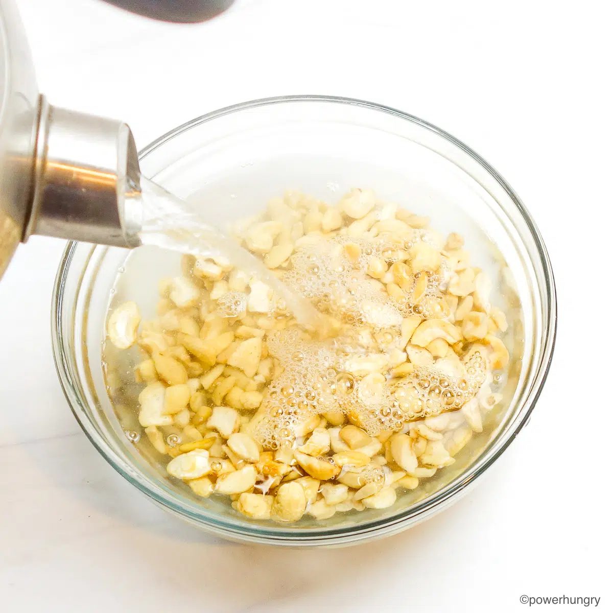 glass bowl of cashews getting covered by boiling water