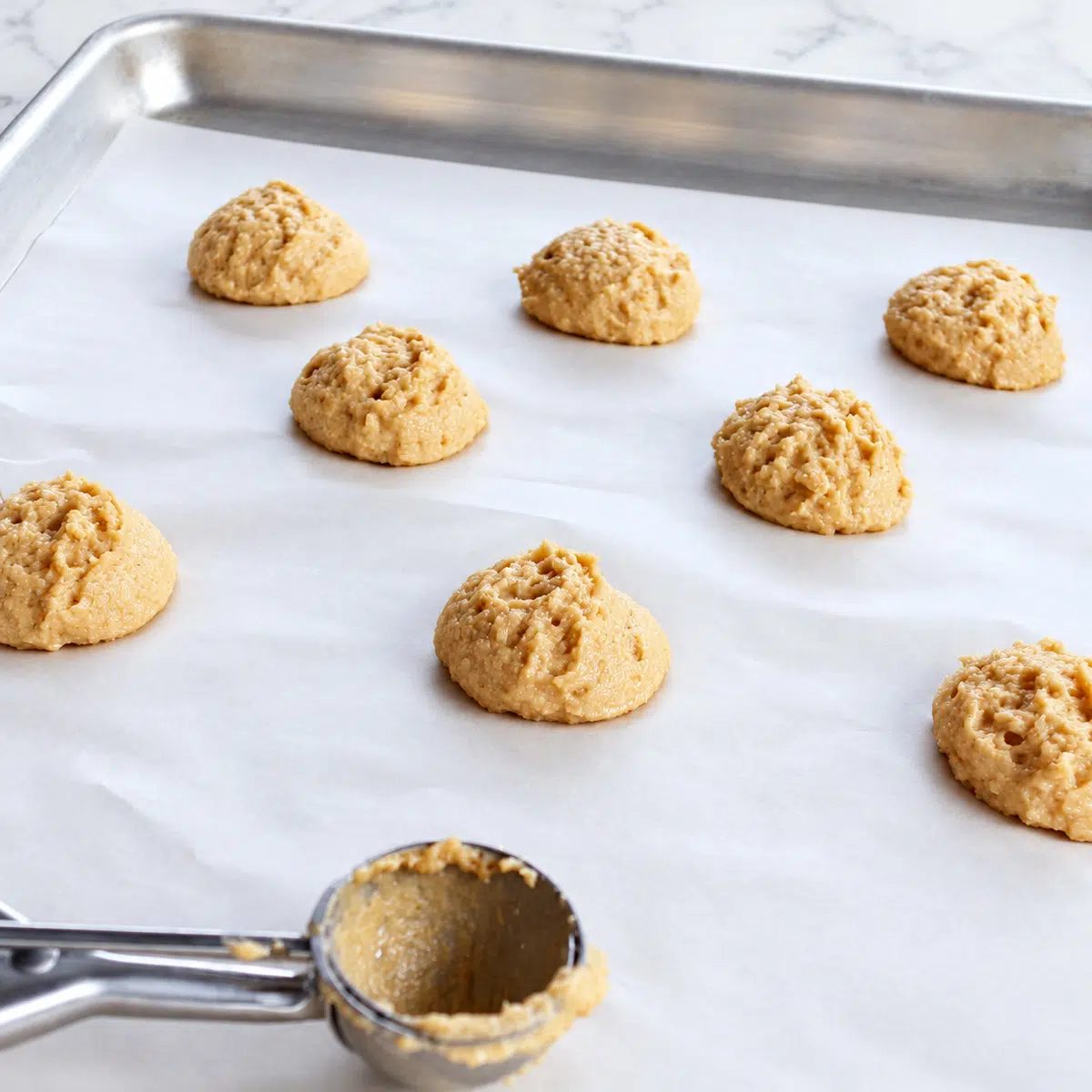 scooped portions of cassava flour cookies on baking sheet