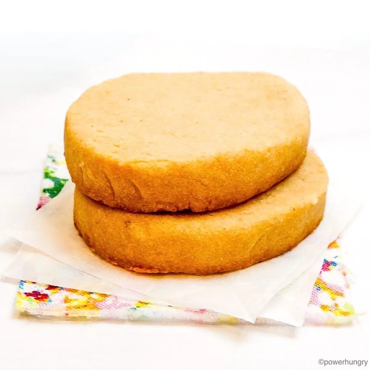 two cassava flour shortbread cookies on a floral napkin