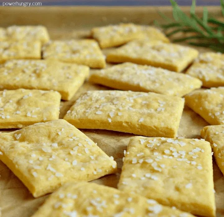 close-up of chickpea flour crackers on a parchment paper -line baking pan