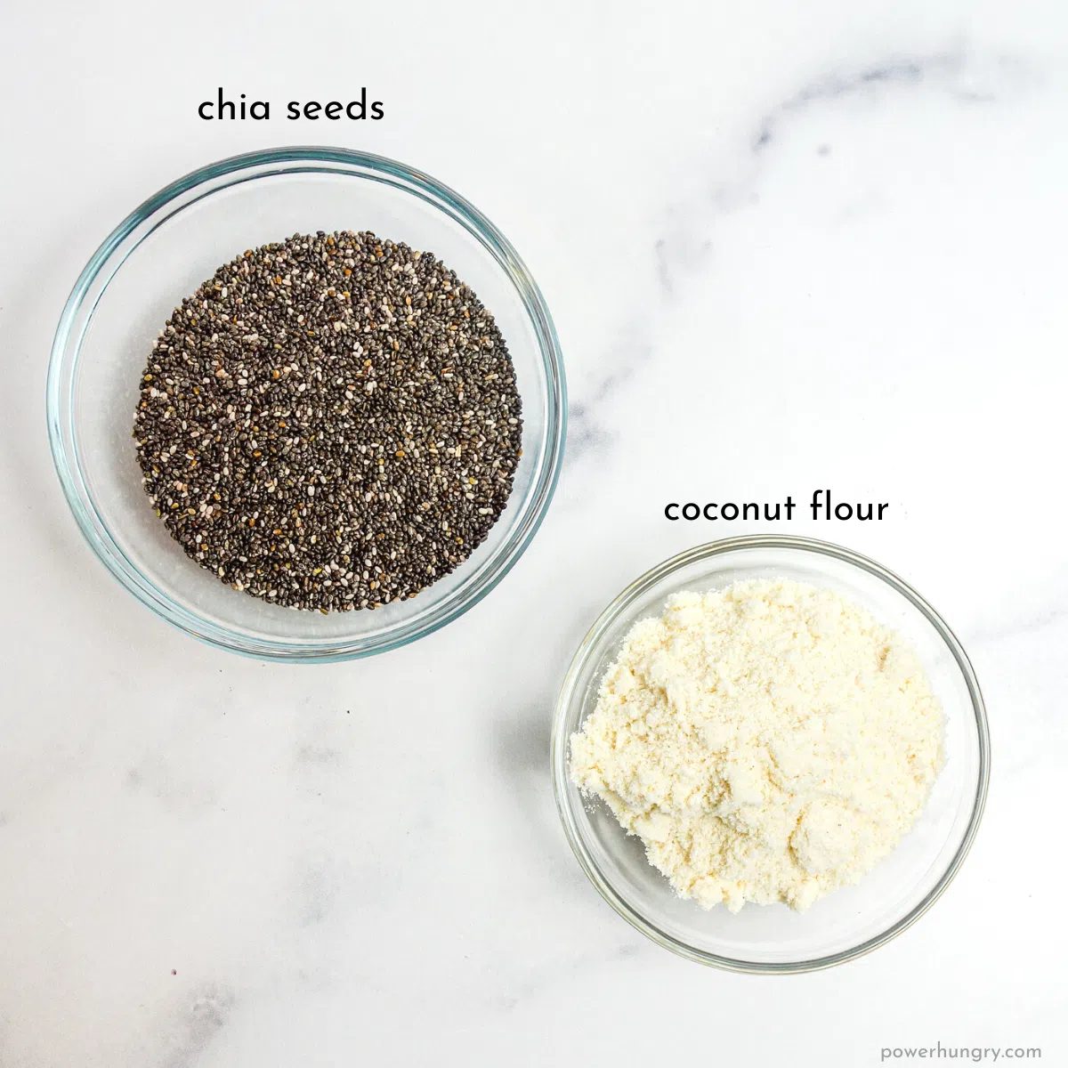 overhead shot of two glass bowl, one filled with coconut flour and the other with chia seeds.