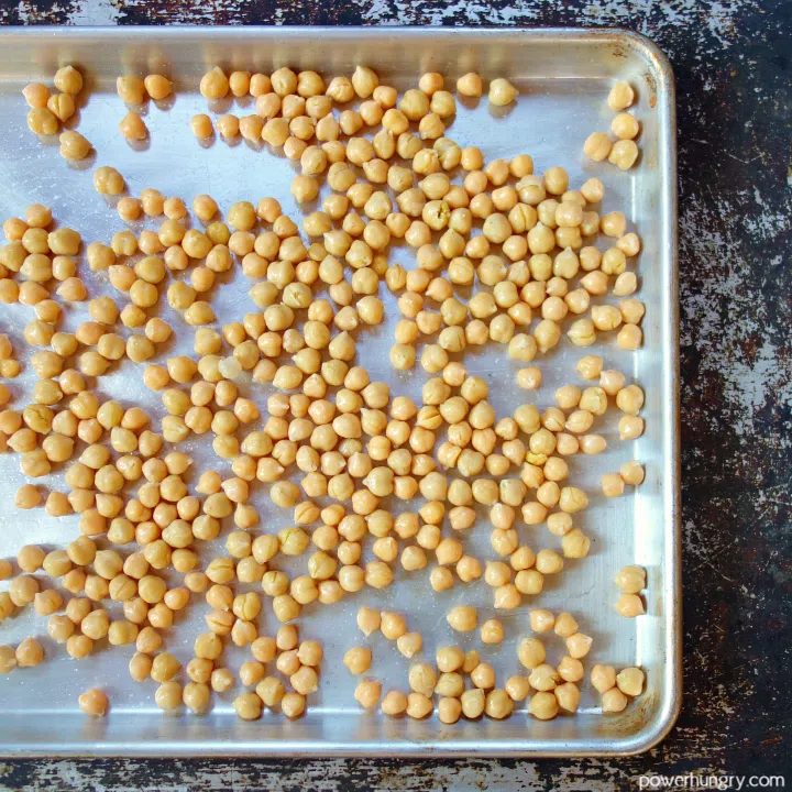 rinsed and blotted canned chickpeas spread out on a large rimmed baking sheet