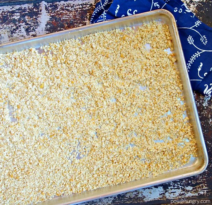 baked chickpeas that have been broken down into crumbs and spread out on a baking sheet for a second bake