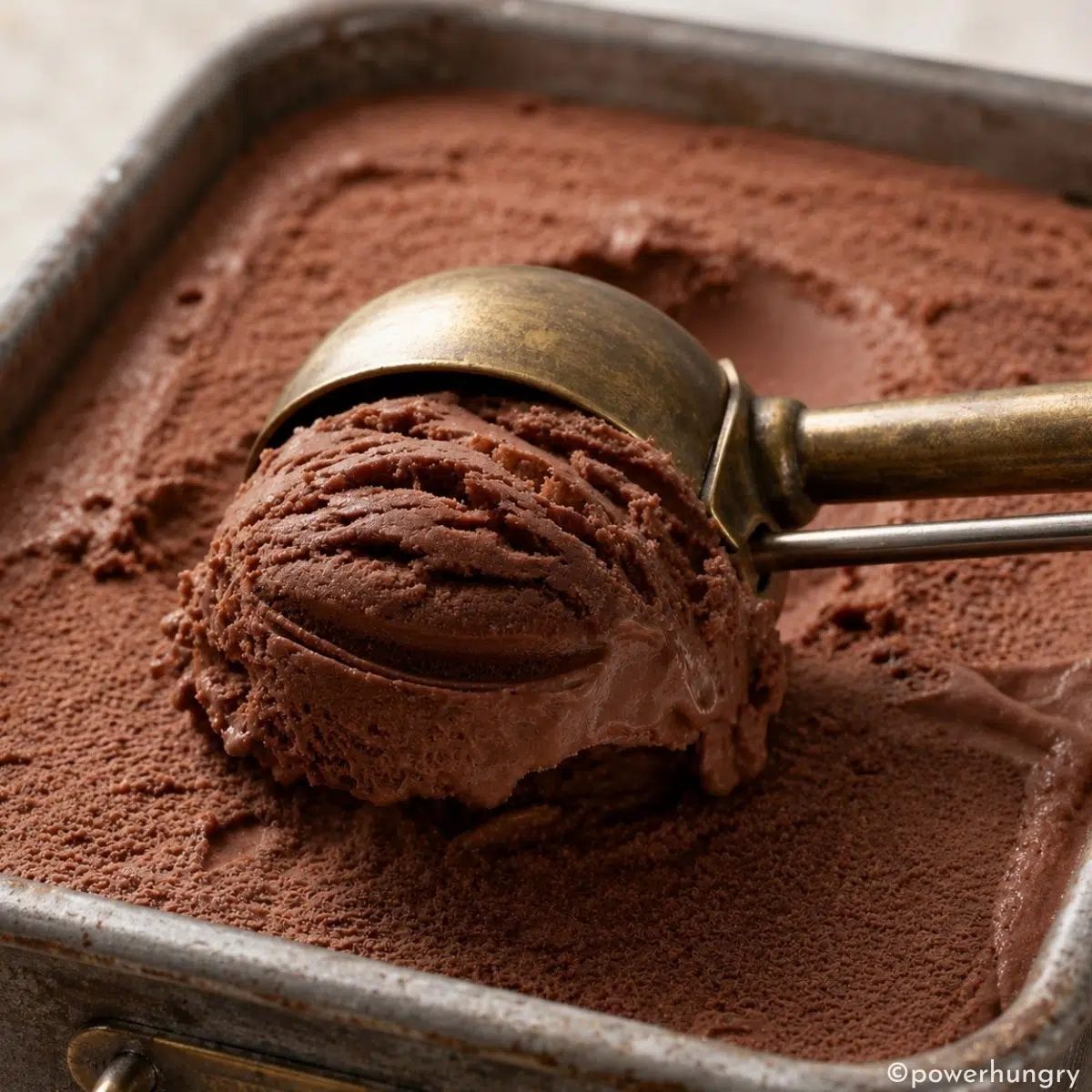 tin filled with vegan chocolate ice ream made from chickpeas, being scooped