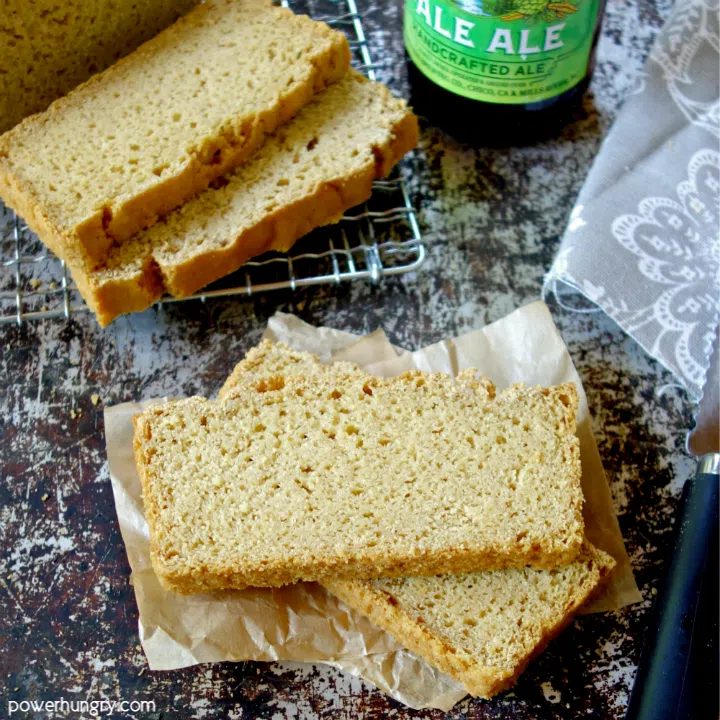 Slices of chickpea flour beer bread with a knfie and bottle of beer