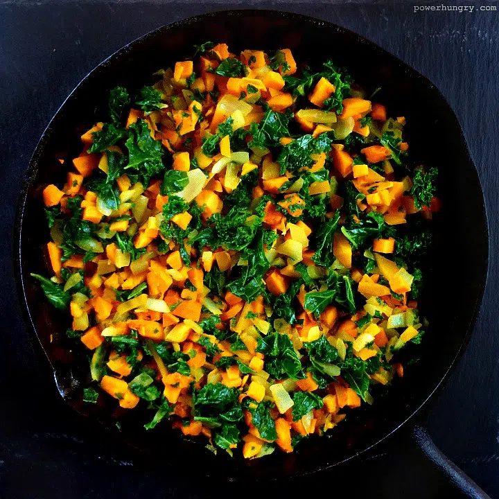 filling ingredients for sweet potato kale frittata in a cast iron skilet