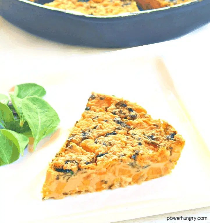 Sweet potato and kale chickpea flour frittata slice on a white plate