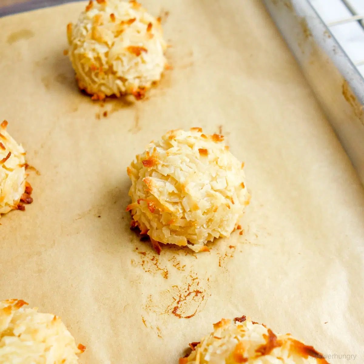 coconut macaroons, baked, on a baking sheet