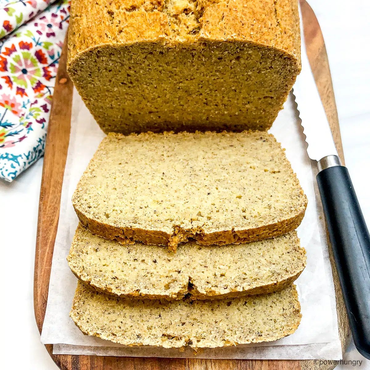 sliced chickpea flour protein bread on a wood cutting board.