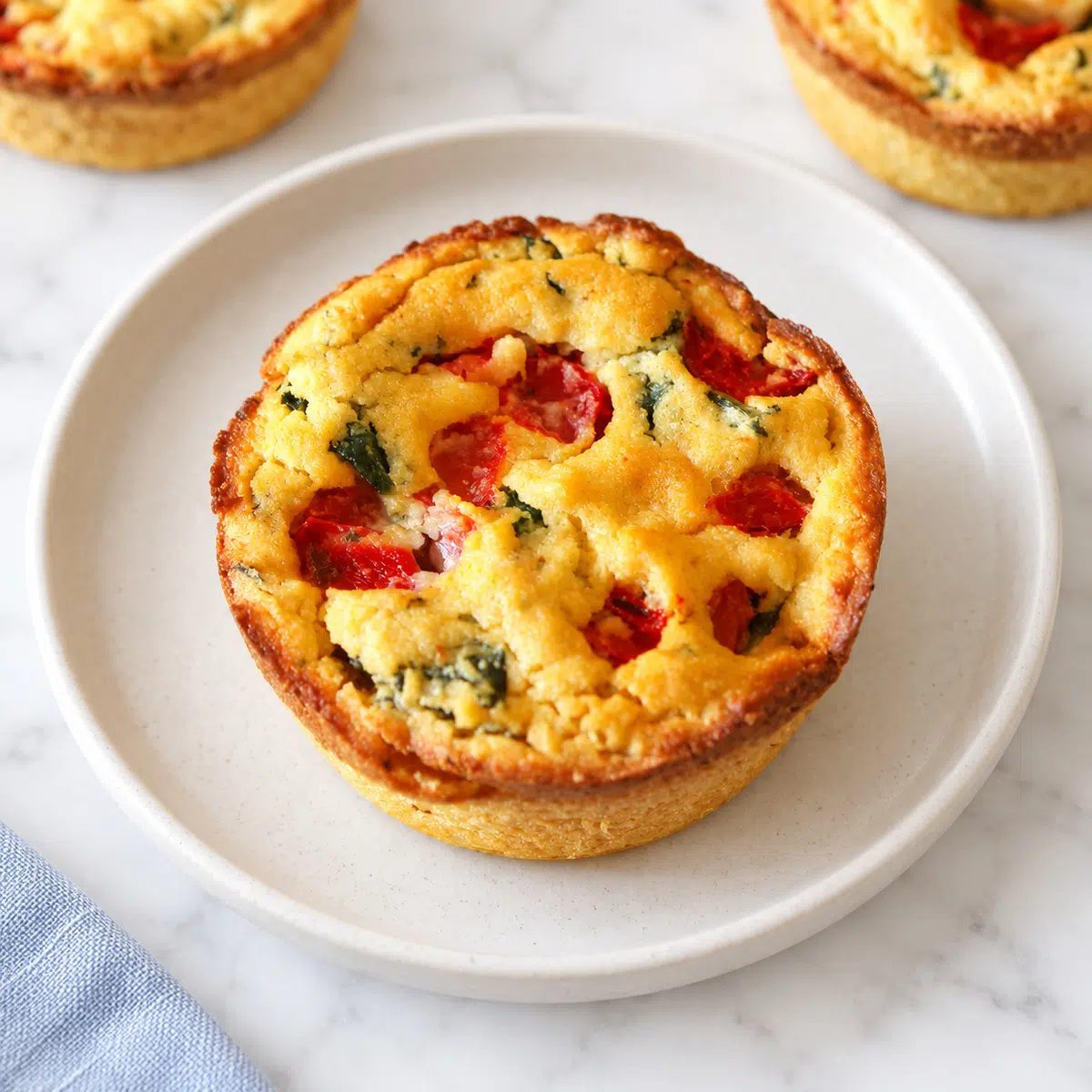 a single chickpea flour quiche on a stoneware plate