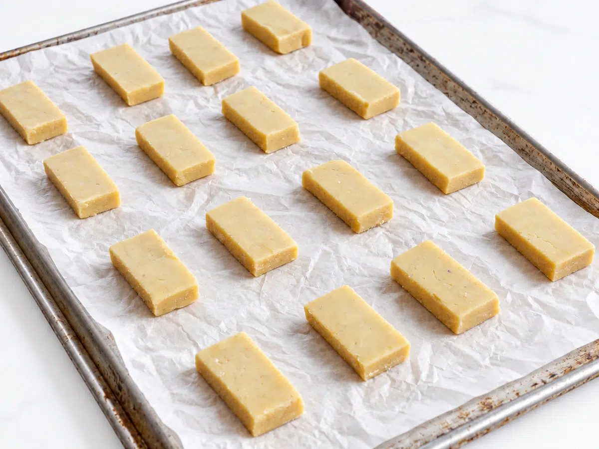 Cut the cookies. Lift the firm dough onto a cutting board and cut it into 32 rectangles, making 8 divisions in one direction and 4 in the other. Arrange half on the baking sheet, 2