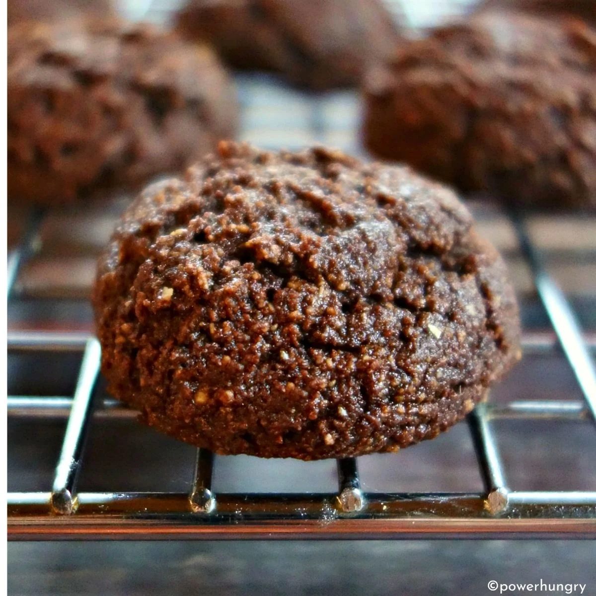 close up of a fudgy chocolate almond flour vegan cookie on a cooling rack