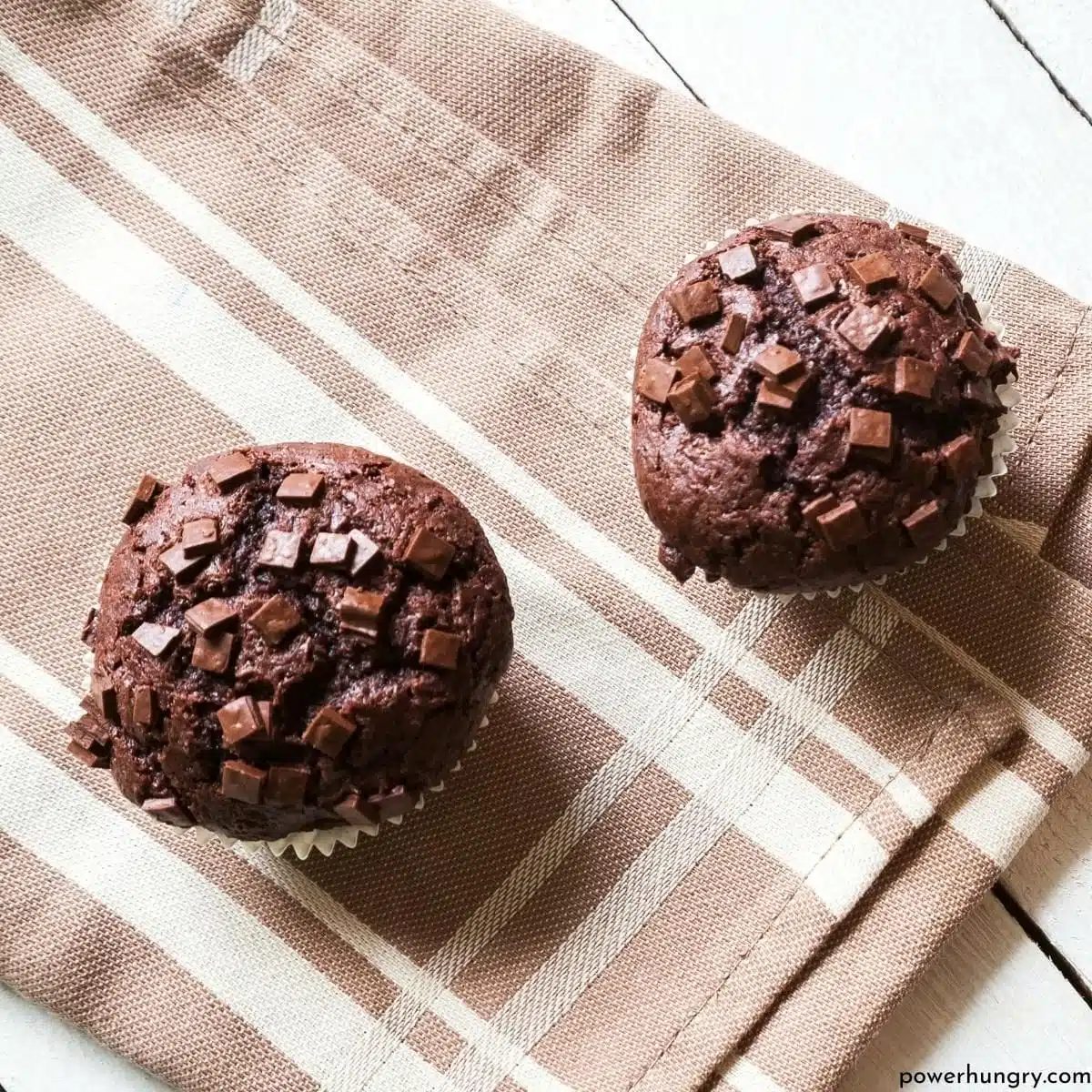 two vegan oil-free chocolate banana teff muffins on a dish towel