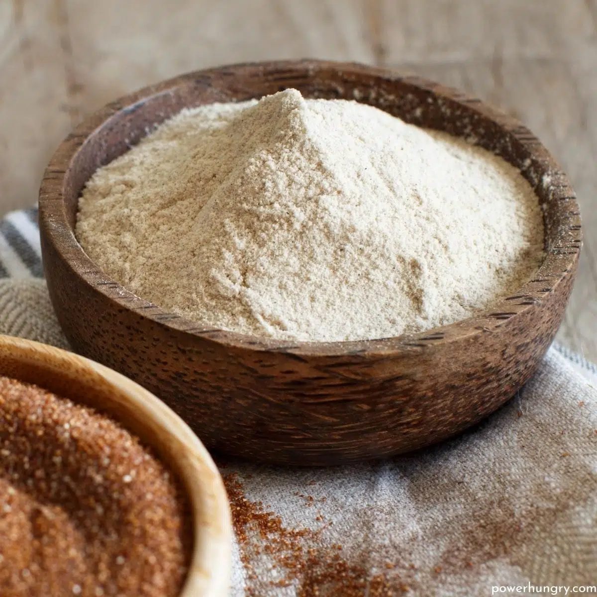 a wooden bowl filled with teff flour