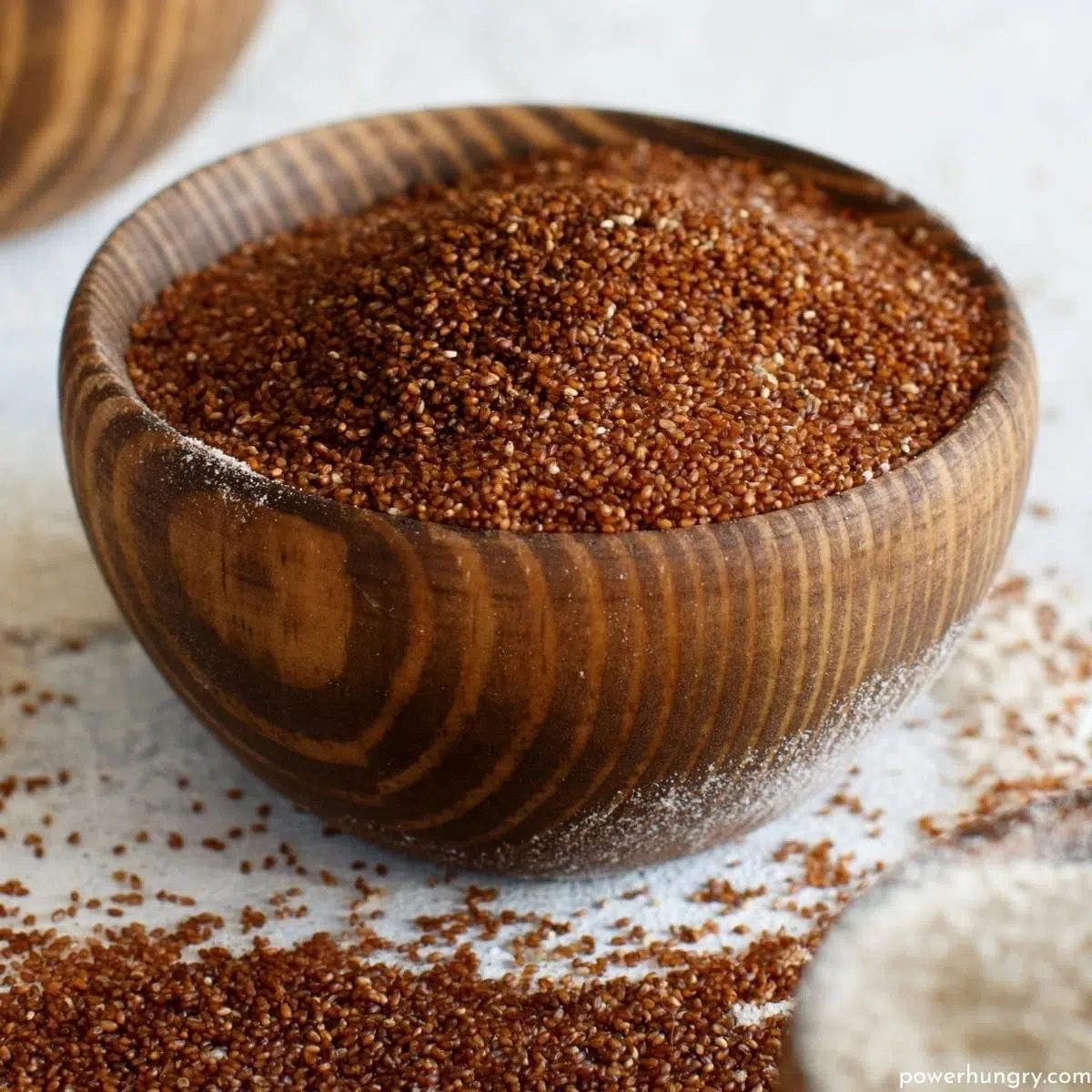 a wooden bowl filled with whole grain teff