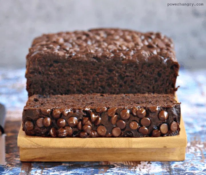 chocolate banana bread made with chickpea flour, sliced, on a wood cutting board