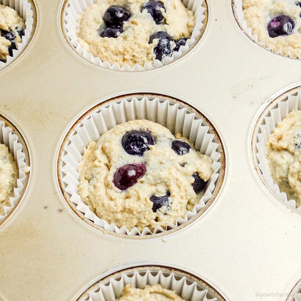 blueberry muffin batter in a muffin tin