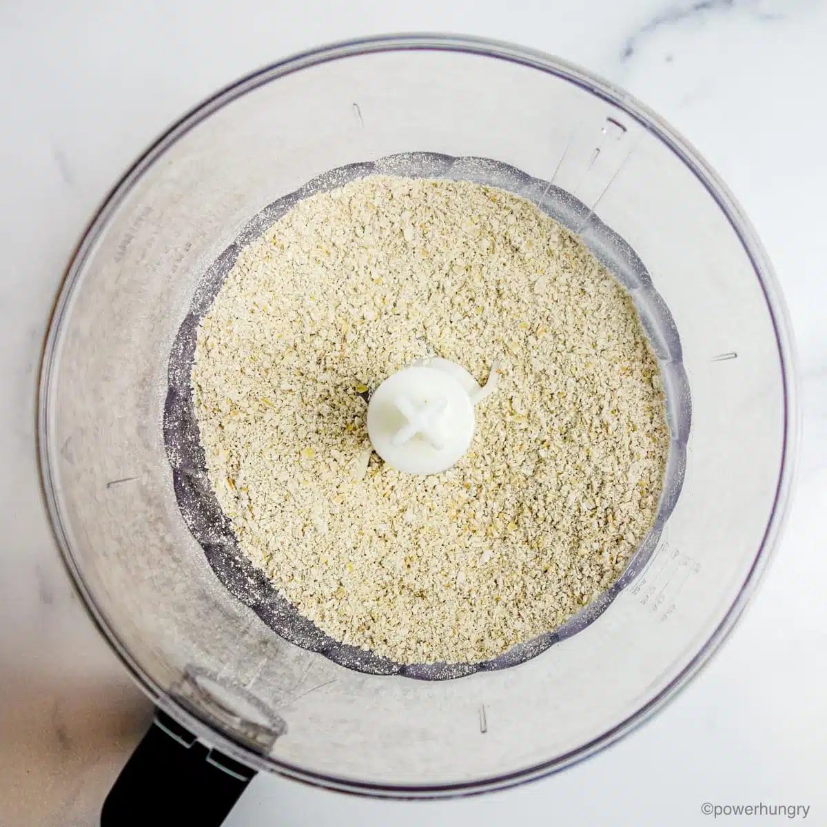 a food processor bowl filled with oat flour