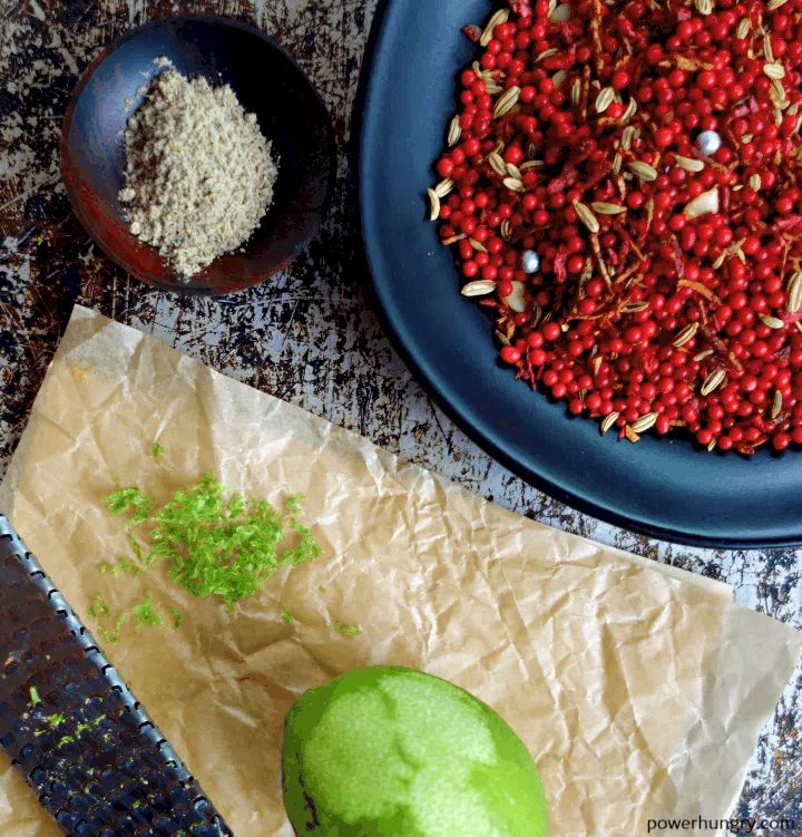 close up of lime zest, muhkwas, lime zest and cardamom on a sheet pan