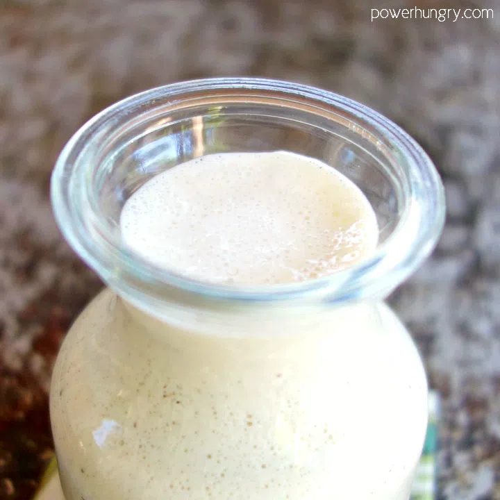 Gass bottle of creamy cashew salad dressing, close up