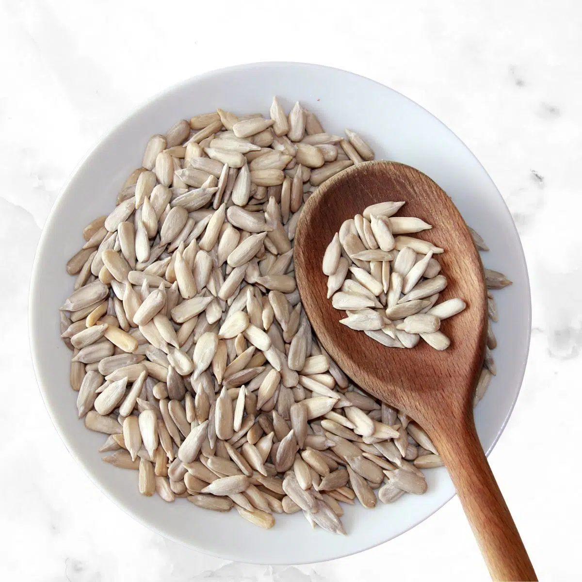 raw sunflower seeds in a white bowl