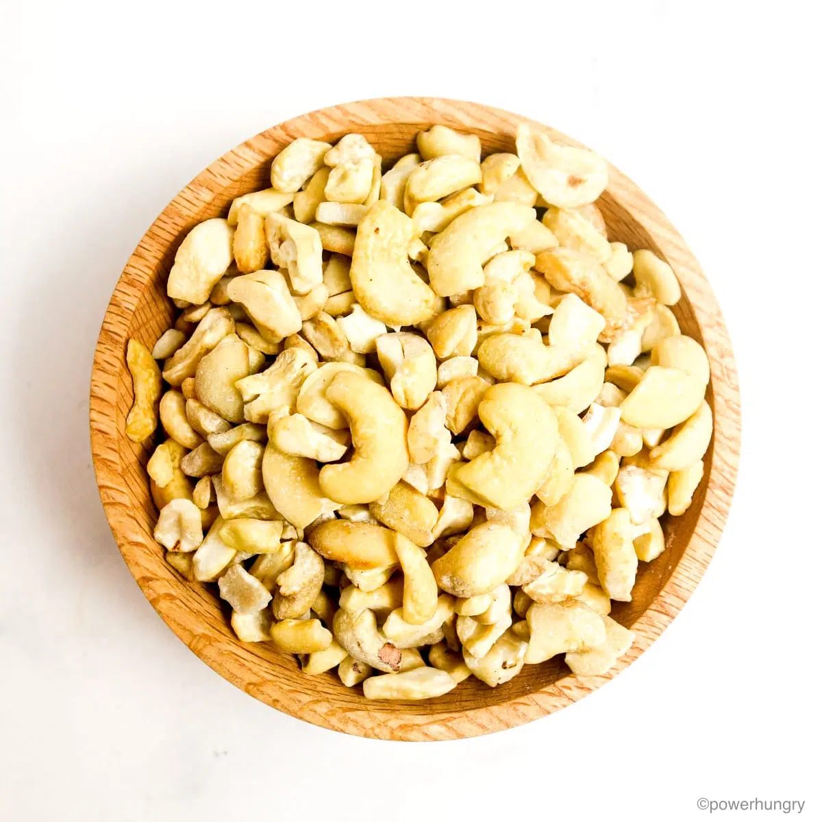 wooden bowl filled with raw cashew pieces
