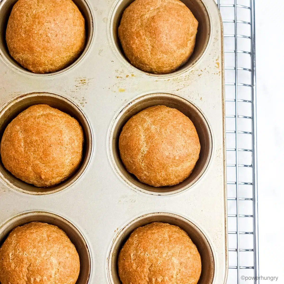 baked flax rolls in a muffin tin, set atop a wire cooling rack