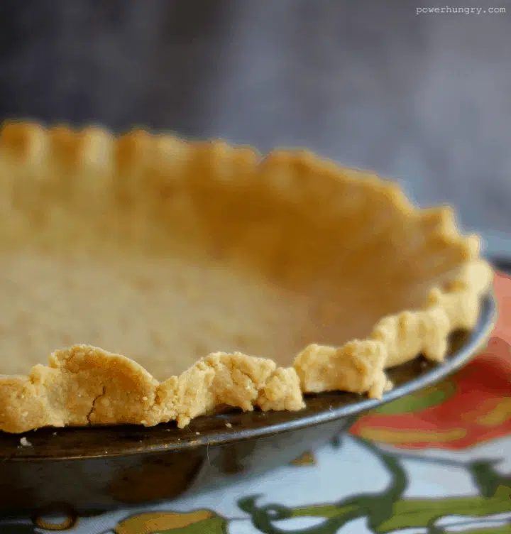 close up of crimped edge of a baked chickpea flour pie crust