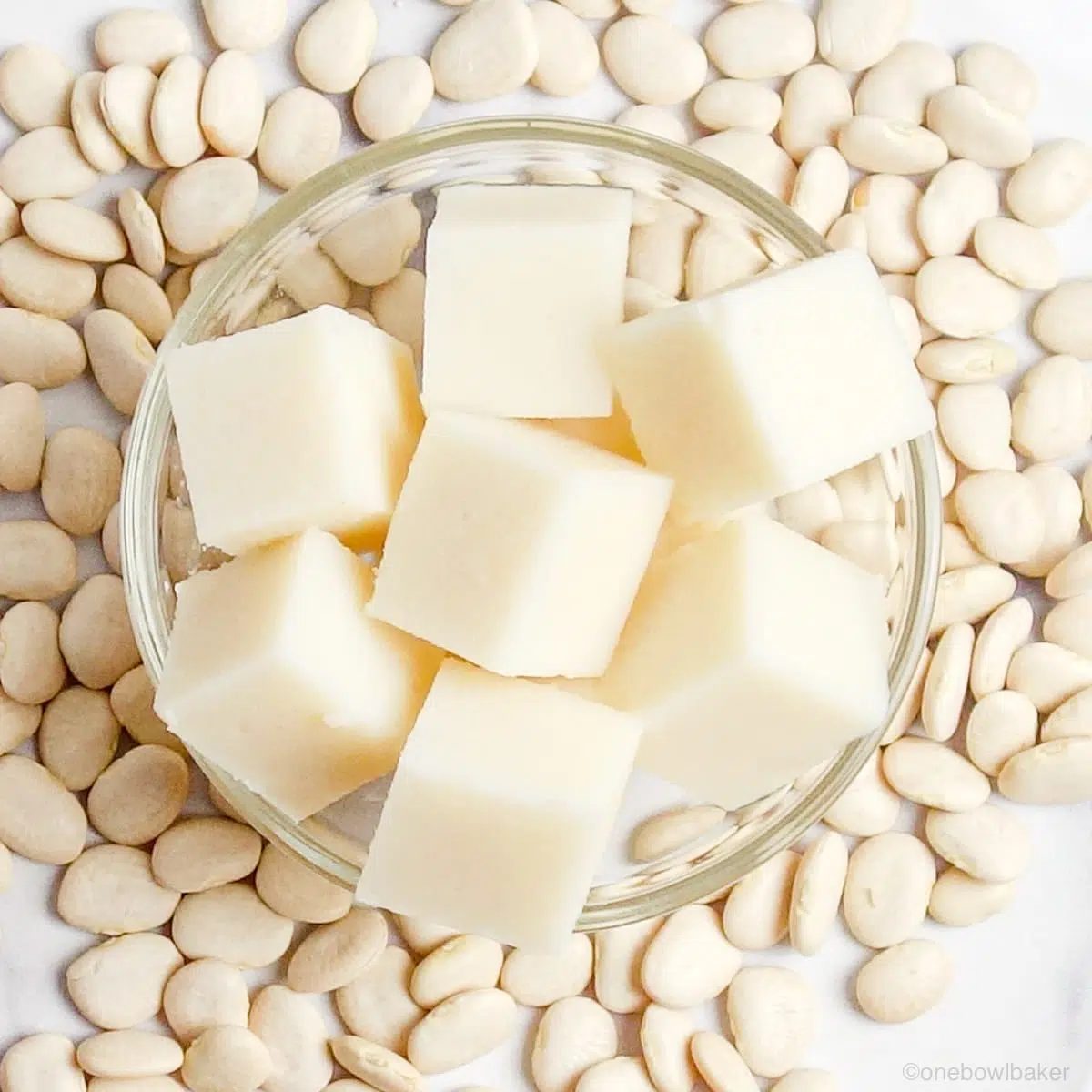 close up of cut white bean tofu in a glass bowl