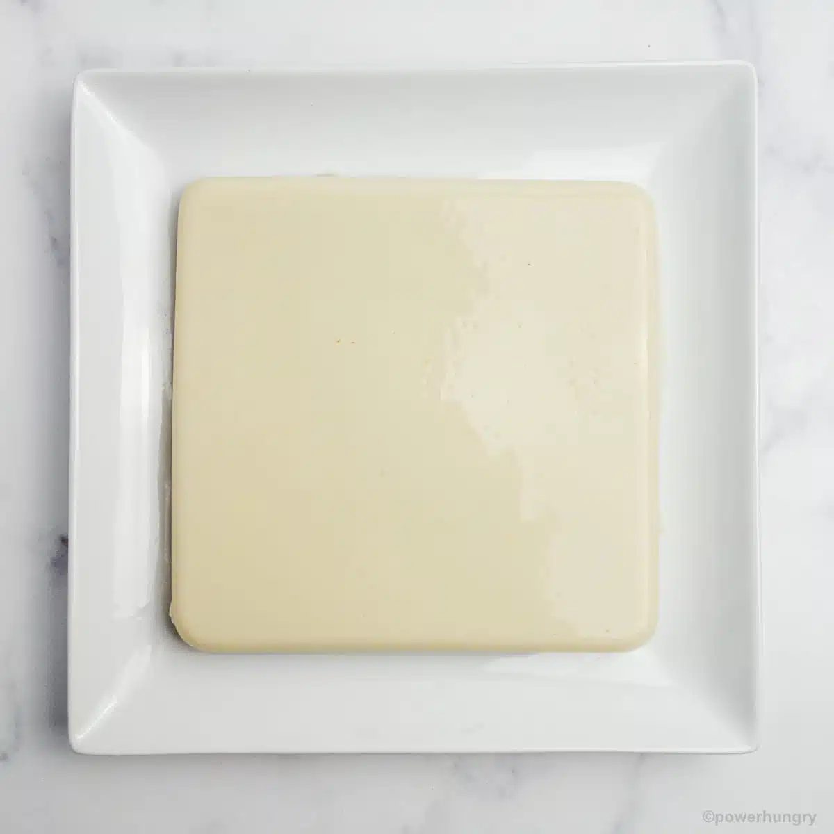 upended block of white bean tofu on a white plate