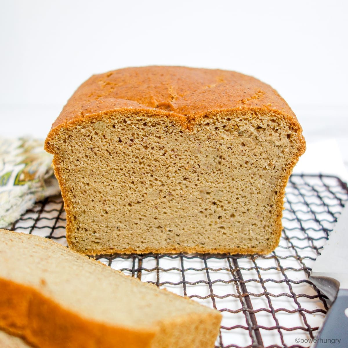 a sliced loaf of red lentil sandwich bread on a wire cooling rack