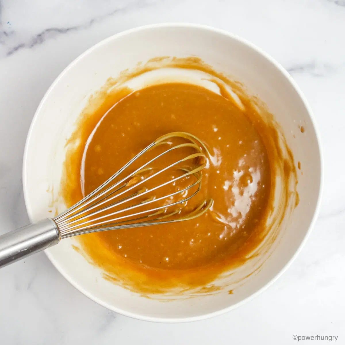 wet ingredients for almond granola in a white mixing bowl