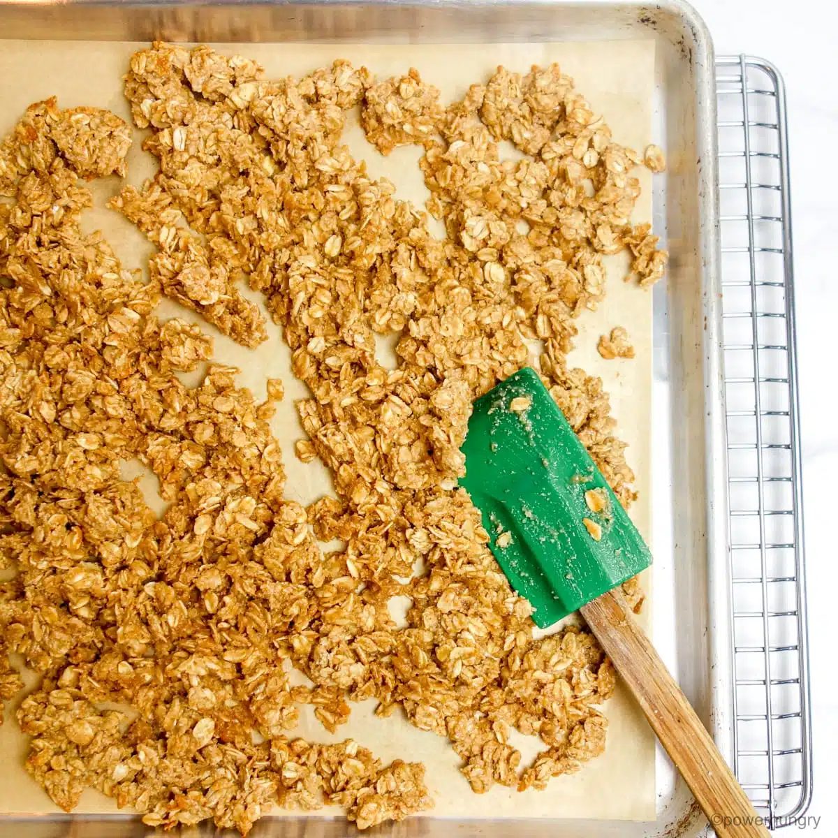 unbaked granola on a parchment lined baking sheet