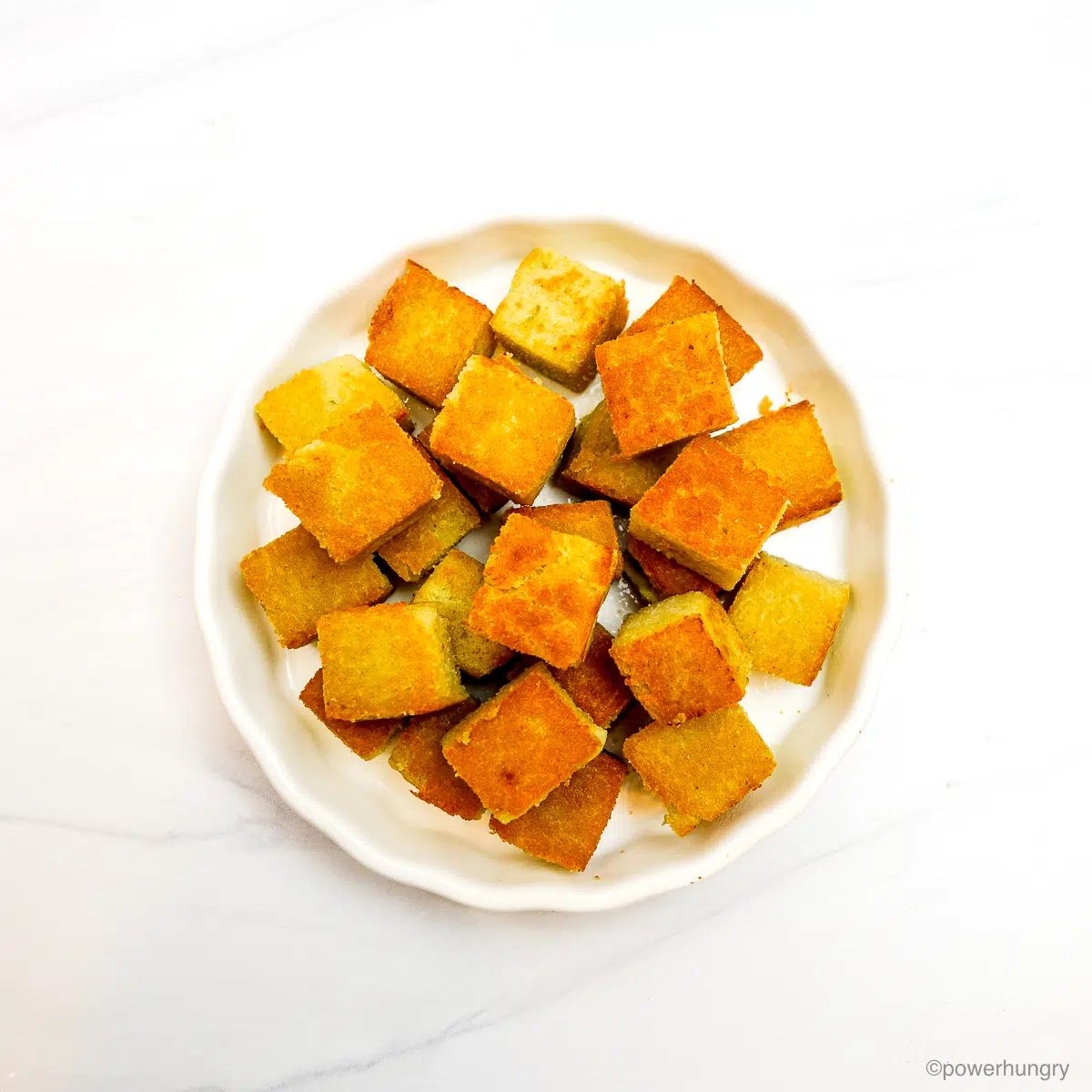 lightly fried cubes of split pea tofu in a white dish
