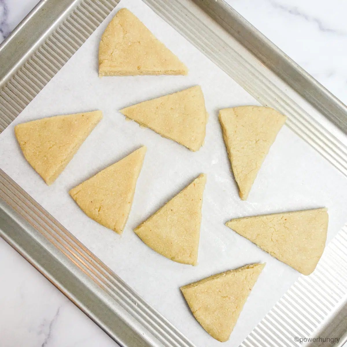 unbaked almond scones on a parchment lined baking sheet