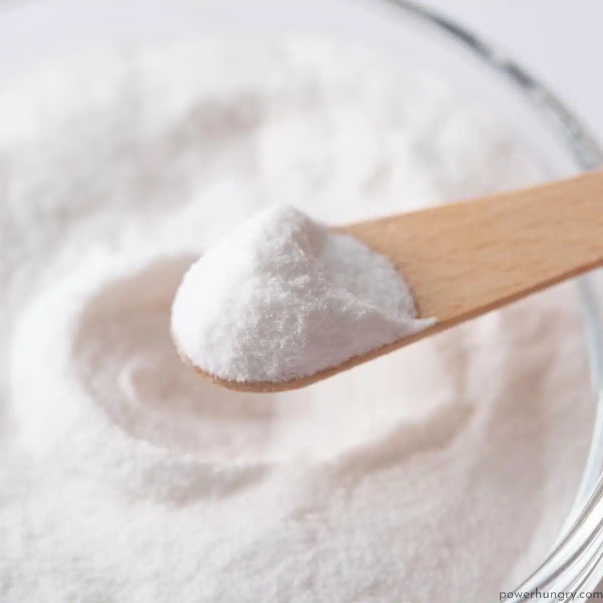 close up of a wooden spoon full of baking powder
