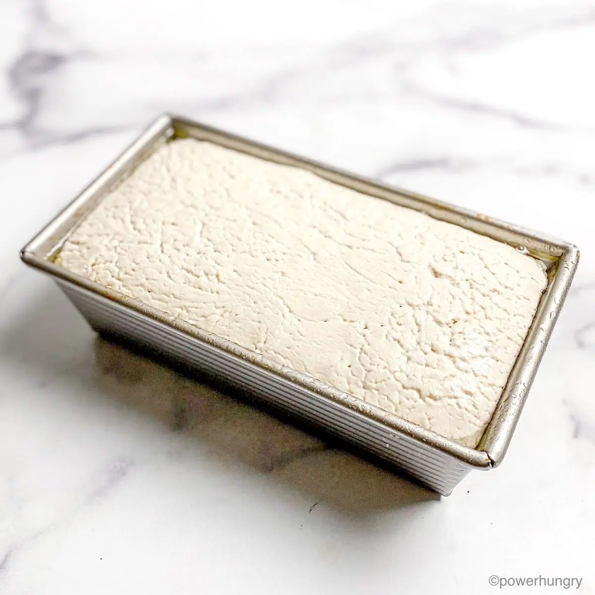 rise bread batter in a silver baking pan