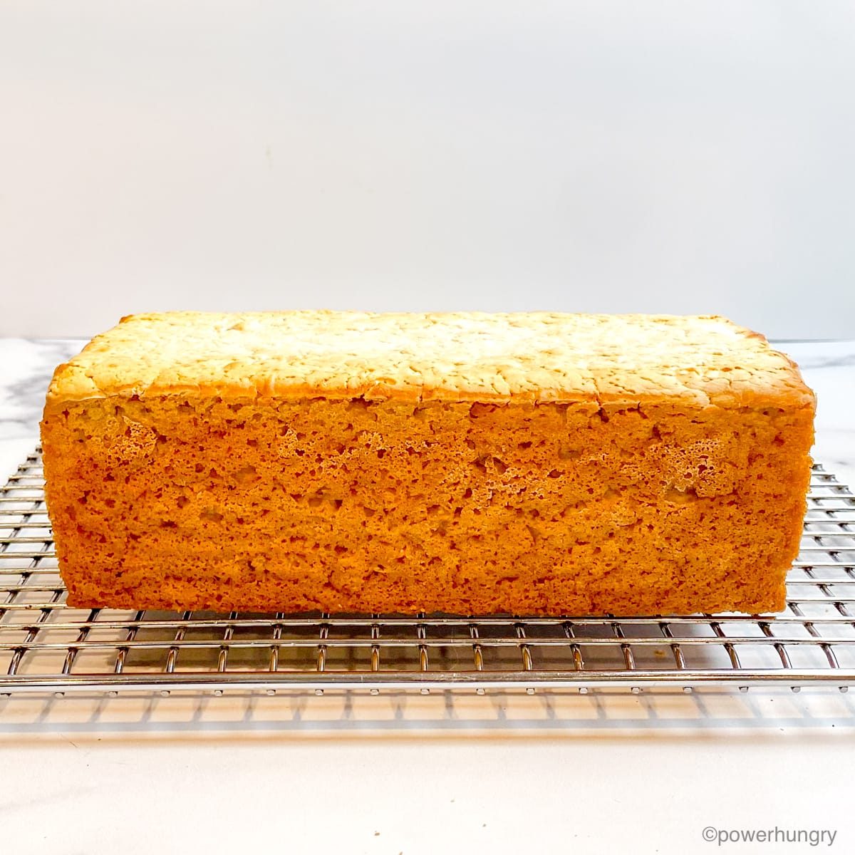 calling loaf of gluten-free bread on a silver cooling rack